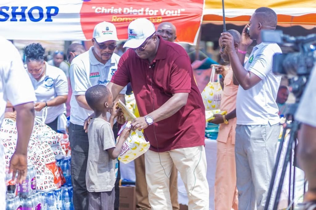 A volunteer handing a care package to a child during an outreach