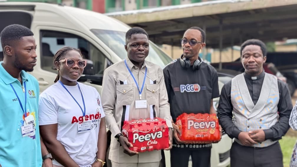 PCGTV and ministry representatives presenting donated drinks outdoors