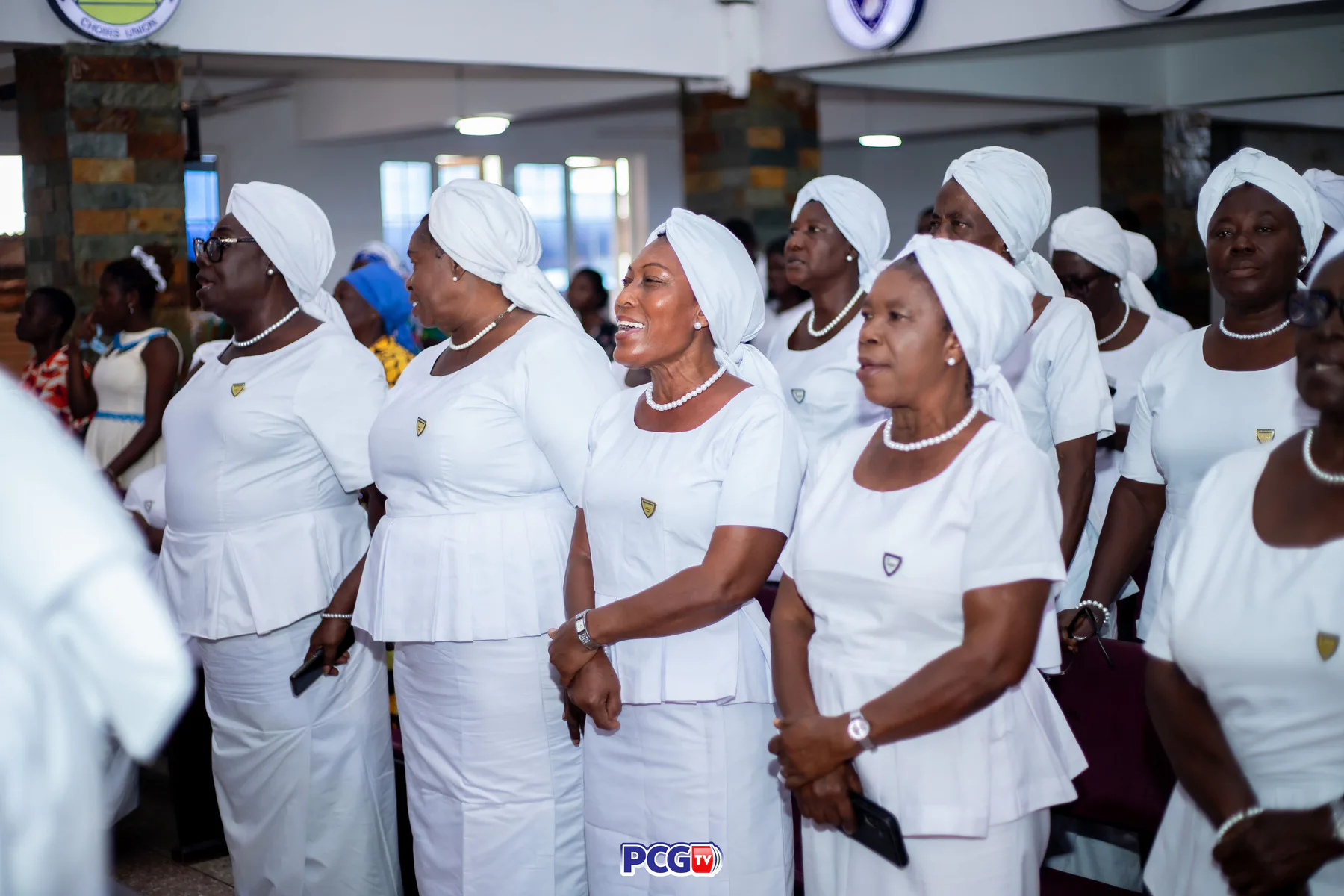 A group of Presbyterian women singing in white uniforms