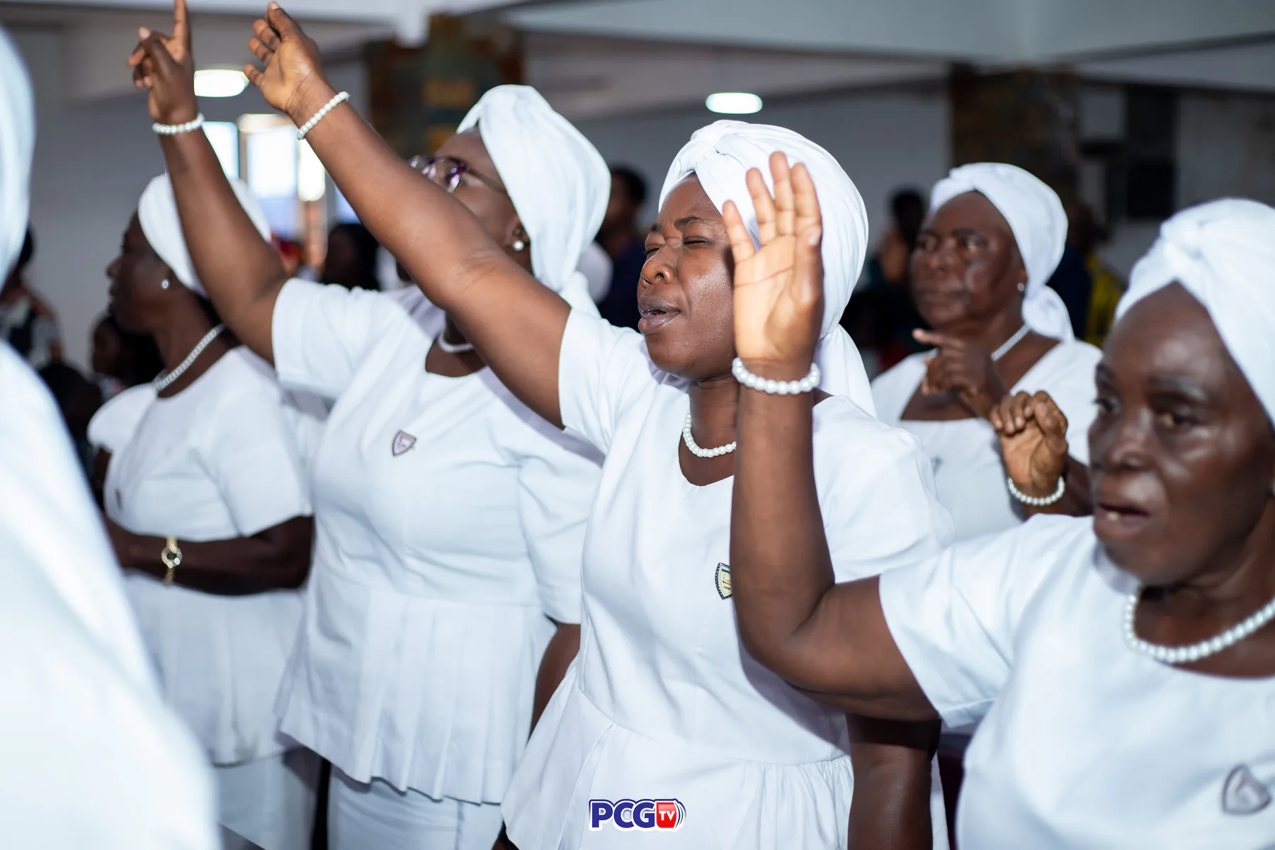 Presbyterian women dressed in white worshipping with raised hands