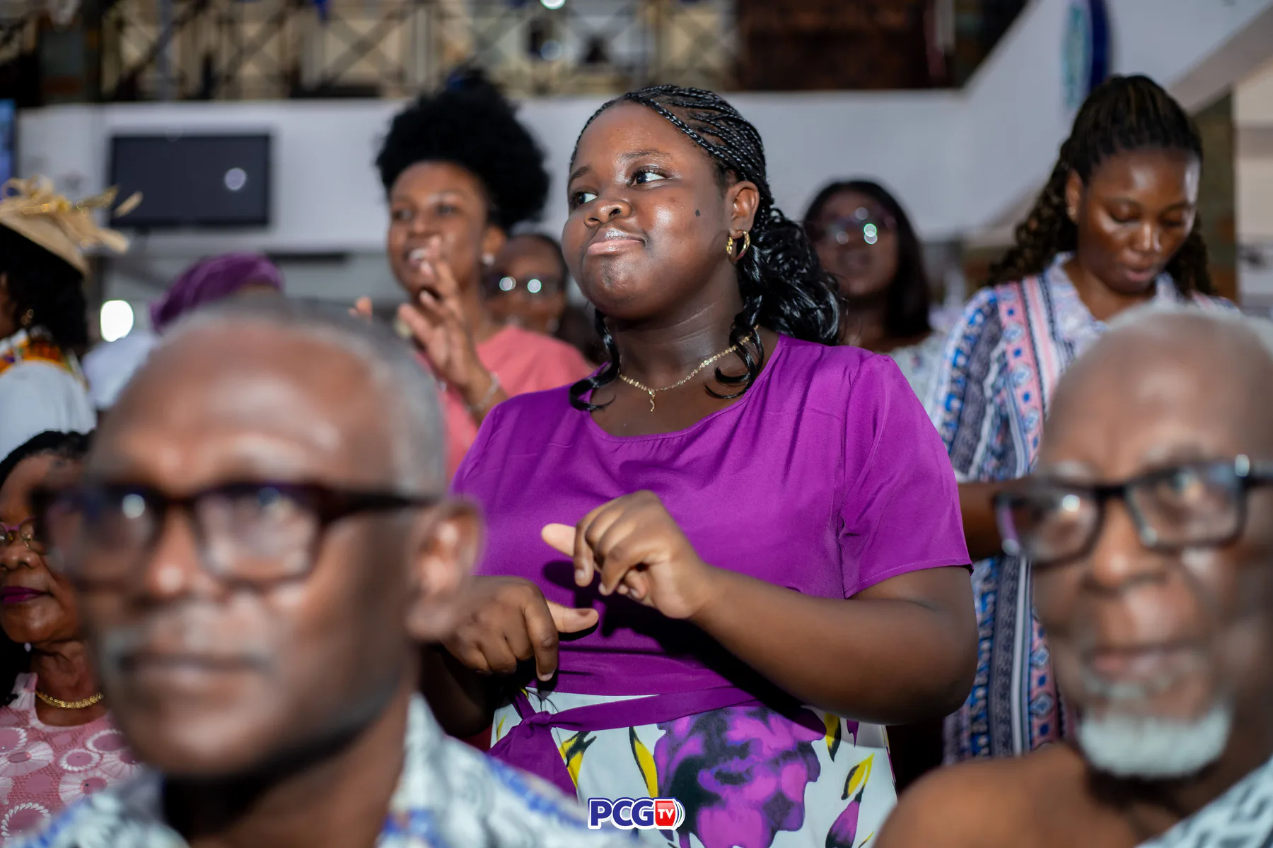 A young woman worshipping among the congregation