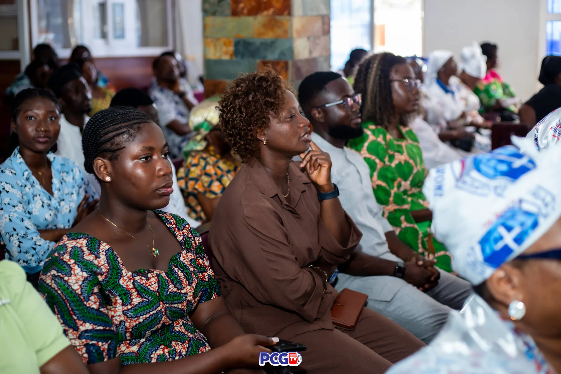 Young adults seated attentively during a Presbyterian gathering