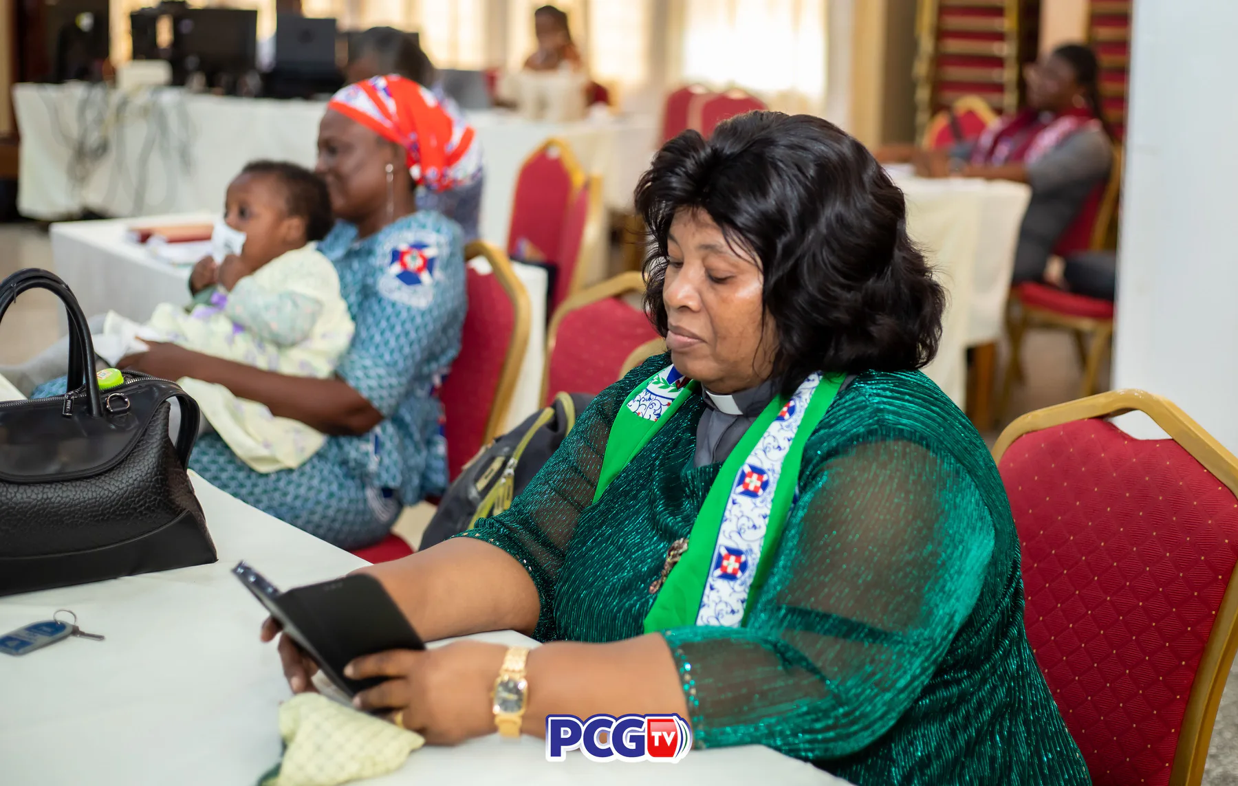 A Presbyterian minister reading from a tablet during a conference