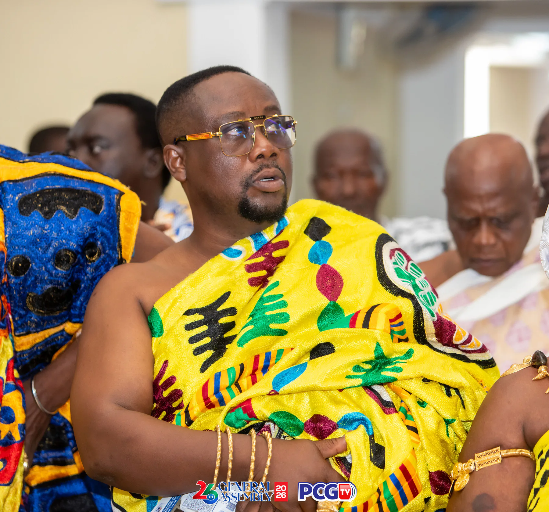 A guest wearing bright traditional Ghanaian cloth at the assembly