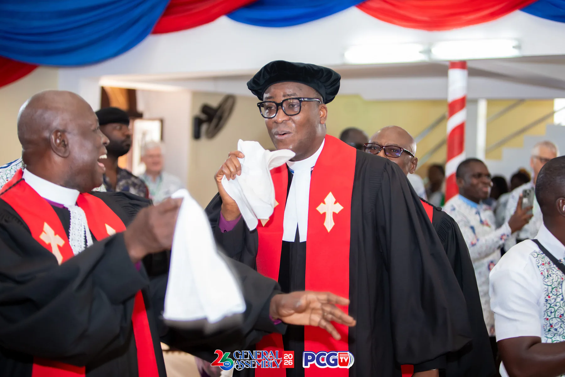 Presbyterian ministers in black robes and red stoles celebrating together